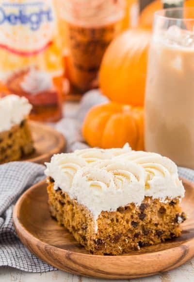 This Pumpkin Chocolate Chip Poke Cake is a deliciously seasonal dessert that's great for potlucks and family gatherings. A dense pumpkin spice cake soaked in sweetened condensed milk and loaded with chocolate chips is topped with a fluffy cheesecake frosting and dusted with cinnamon!