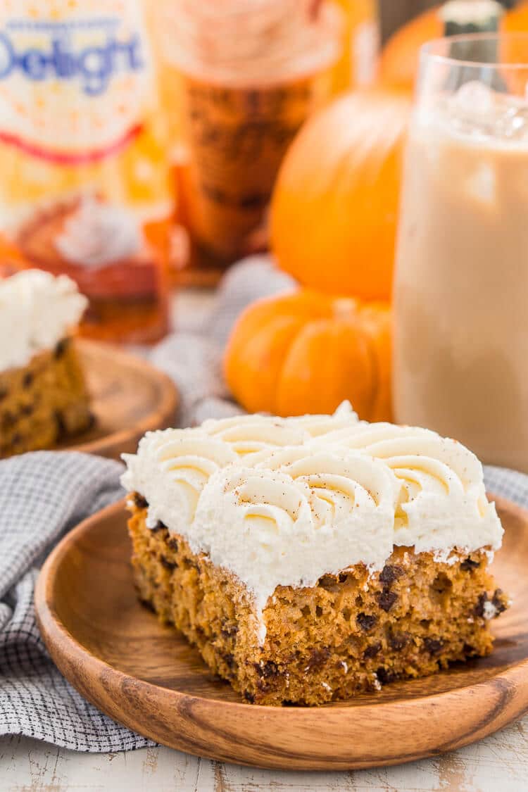 This Pumpkin Chocolate Chip Poke Cake is a deliciously seasonal dessert that's great for potlucks and family gatherings. A dense pumpkin spice cake soaked in sweetened condensed milk and loaded with chocolate chips is topped with a fluffy cheesecake frosting and dusted with cinnamon!