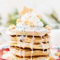 These Sugar Cookie Pancakes will add holiday cheer to your morning routine. Trade in traditional buttermilk for thick, fluffy, and sweet ricotta based pancakes laced with sugar cookie creamer, and topped with baked sugar cookies, icing, whipped cream, and sprinkles!