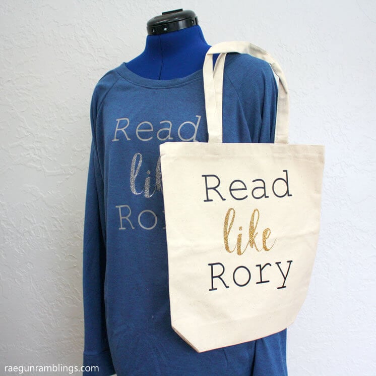 A mannequin wearing a blue long-sleeved shirt and a canvas bag that both say, \"Read Like Rory\"