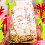 Close up photo of bags of reindeer food on a wooden tray with paper reindeer around them.