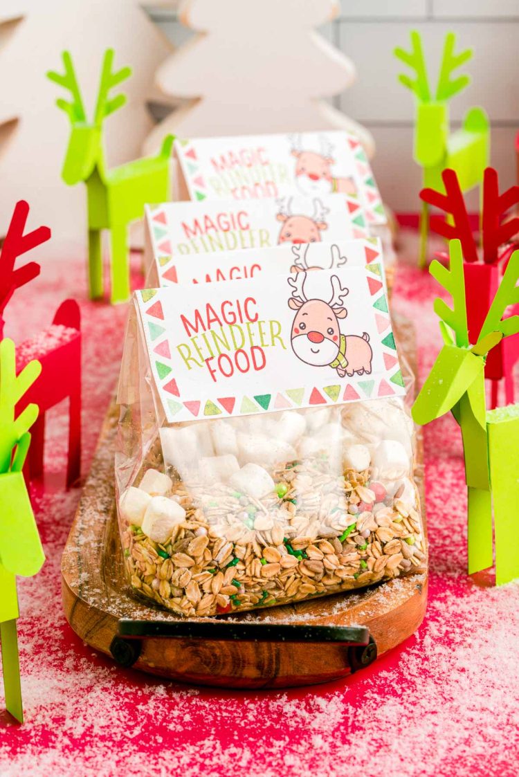 Close up photo of bags of reindeer food on a wooden tray with paper reindeer around them.
