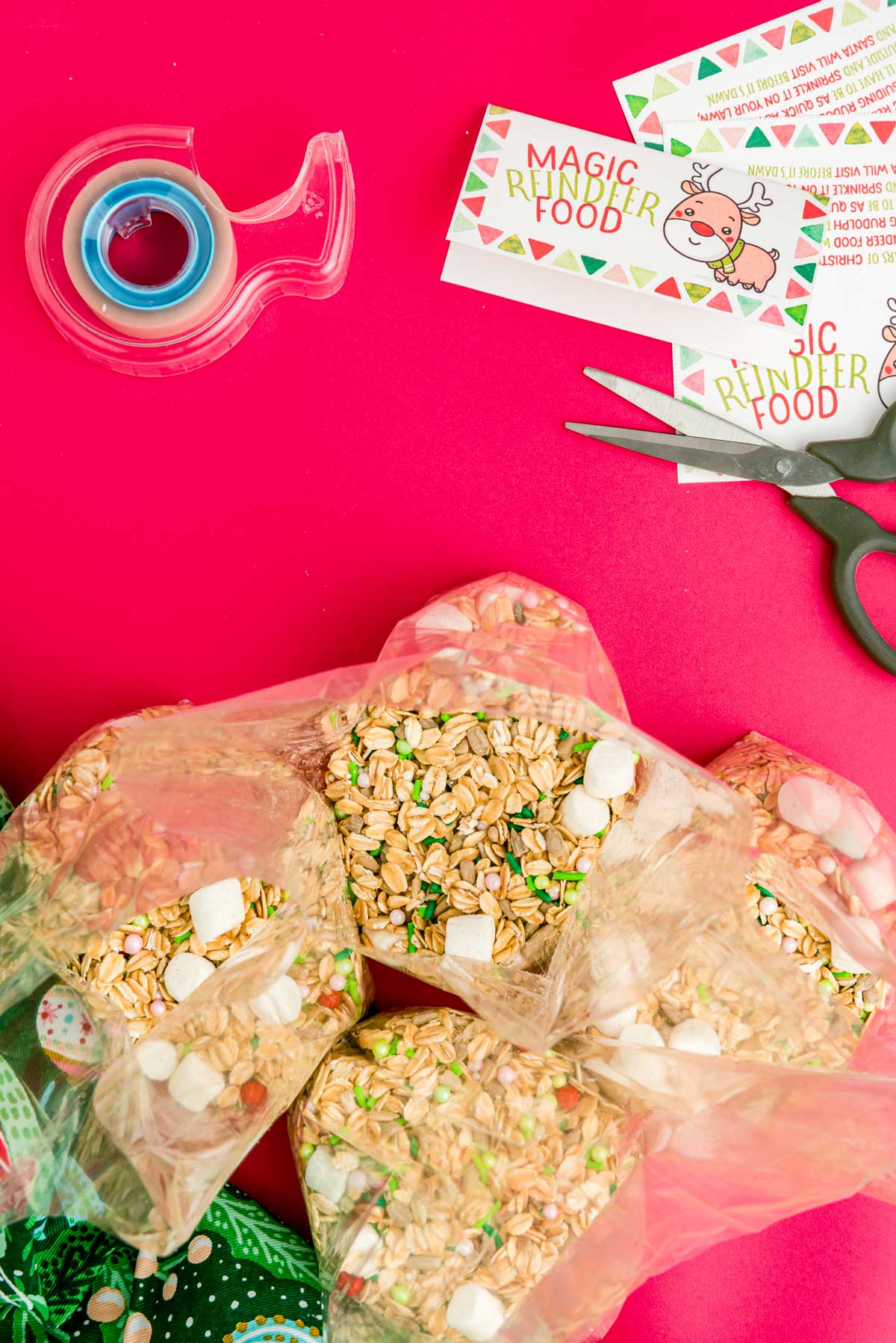 Overhead photo of magic reindeer food in cello bags with labels, scissors, and tape off to the side.