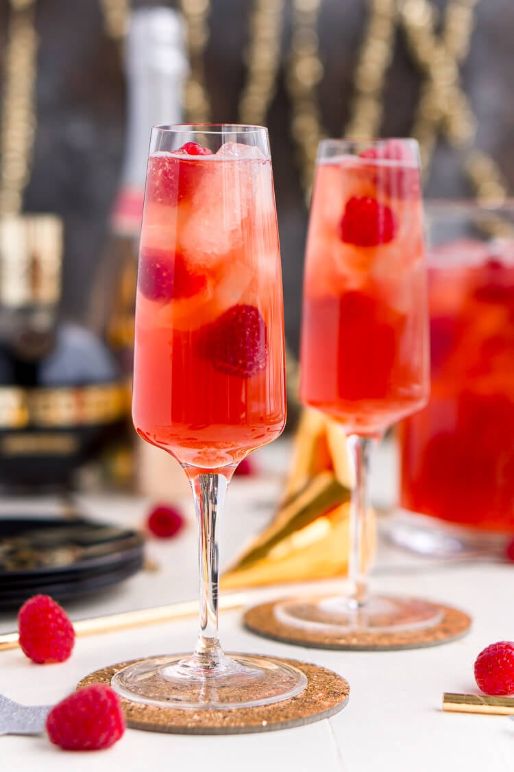 New Year's Eve Champagne Punch is loaded with Triple Sec, blackberry brandy, Chambord, pineapple juice, ginger ale, and champagne for a drink that's sure to impress all your NYE party guests!