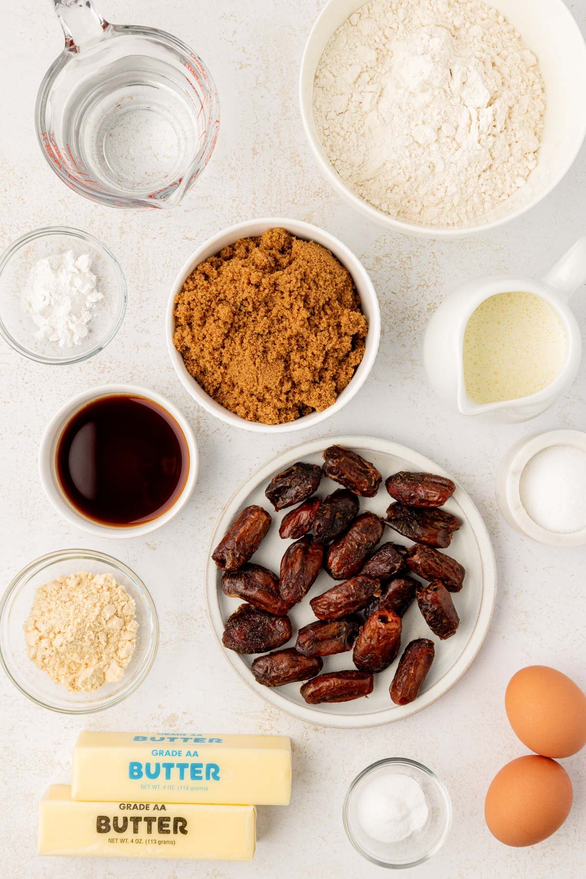Overhead photo of ingredients to make sticky toffee pudding on a white counter.