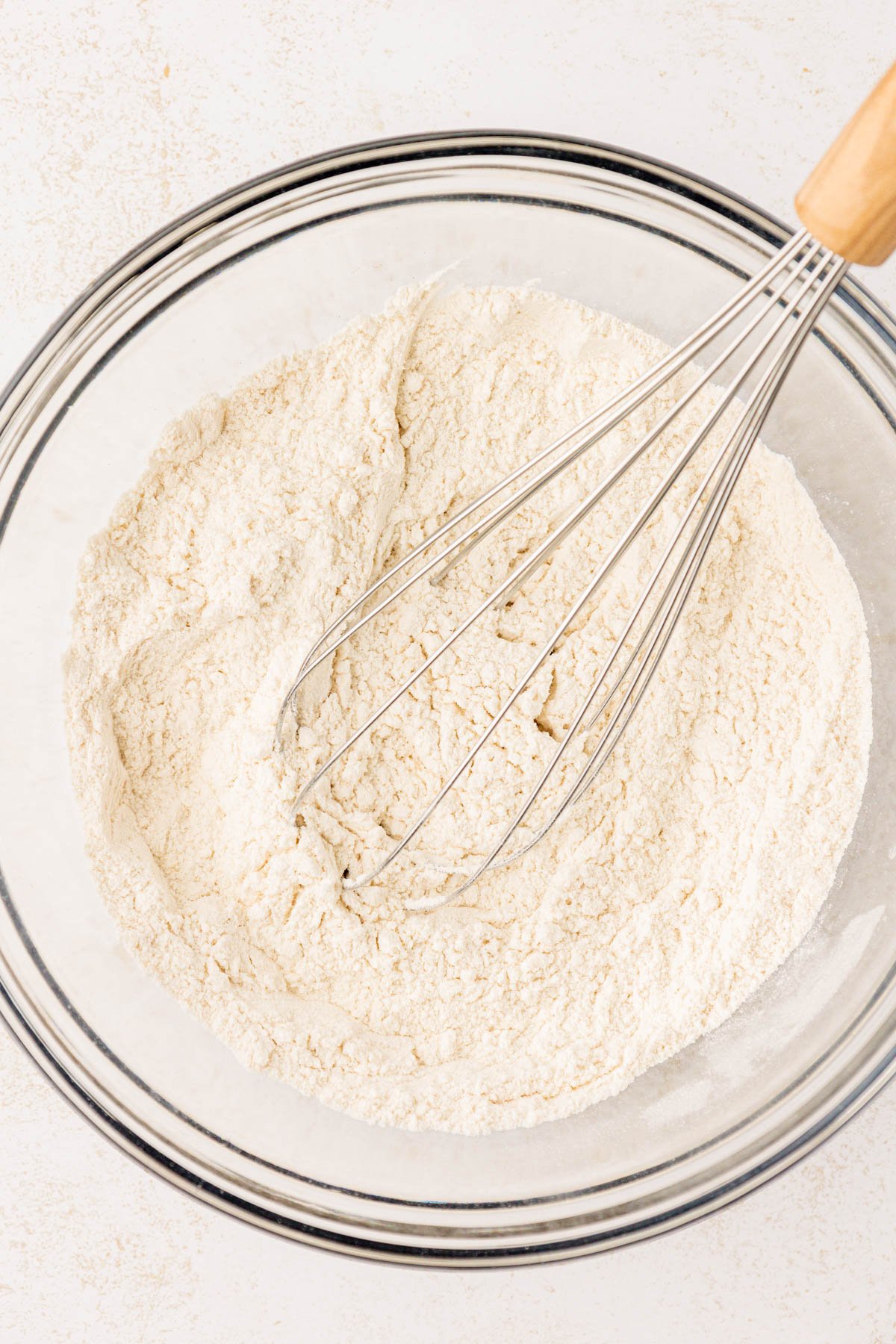 Dry ingredients whisked together in a glass bowl.