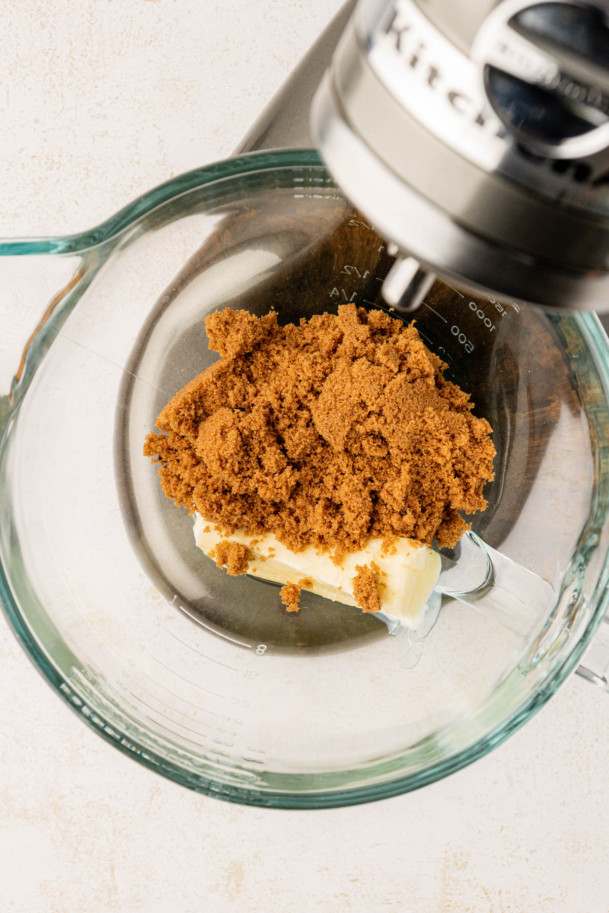 Butter and dark brown sugar in a glass mixing bowl.