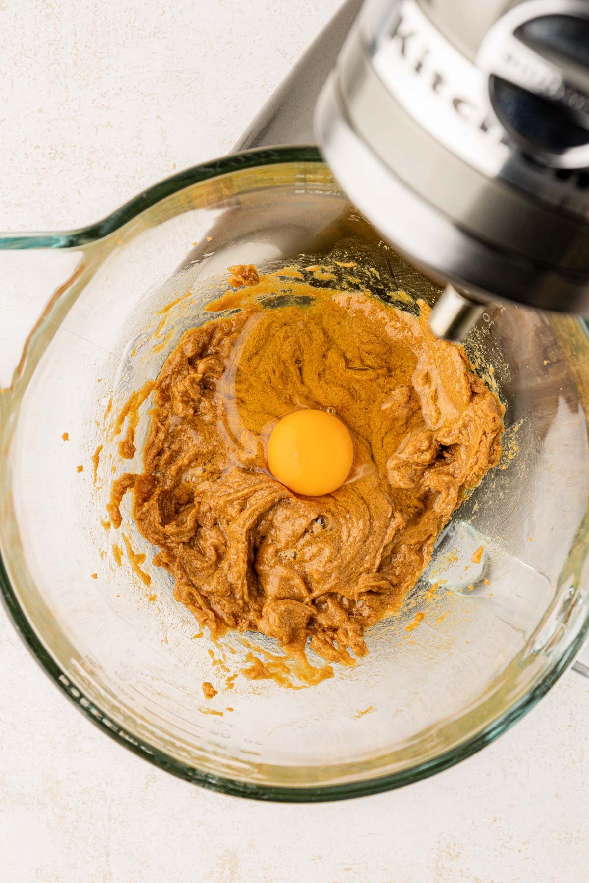 Egg being added to batter for sticky toffee pudding. 