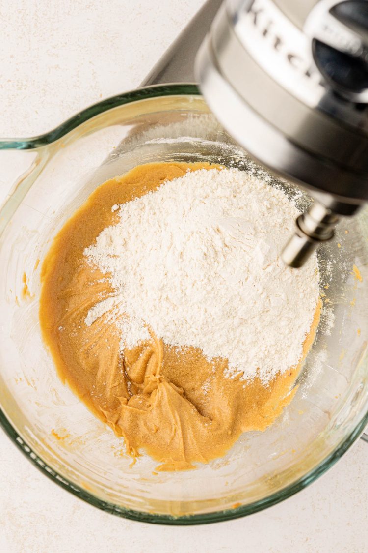 Dry ingredients being added to cake batter in a mixing bowl.