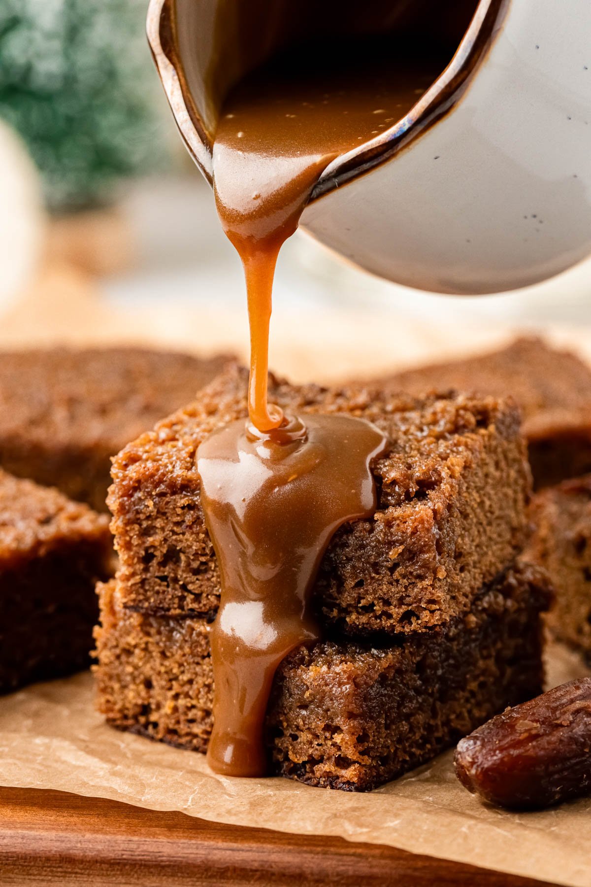 Toffee sauce being poured over sticky toffee pudding.