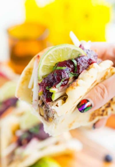 Pulled Pork Tacos with Blueberry Barbecue Sauce are perfect for game days and weeknights! A pork shoulder is slow cooked in root beer, topped with an apple slaw and homemade blueberry barbecue sauce all nestled in delicious naan bread!