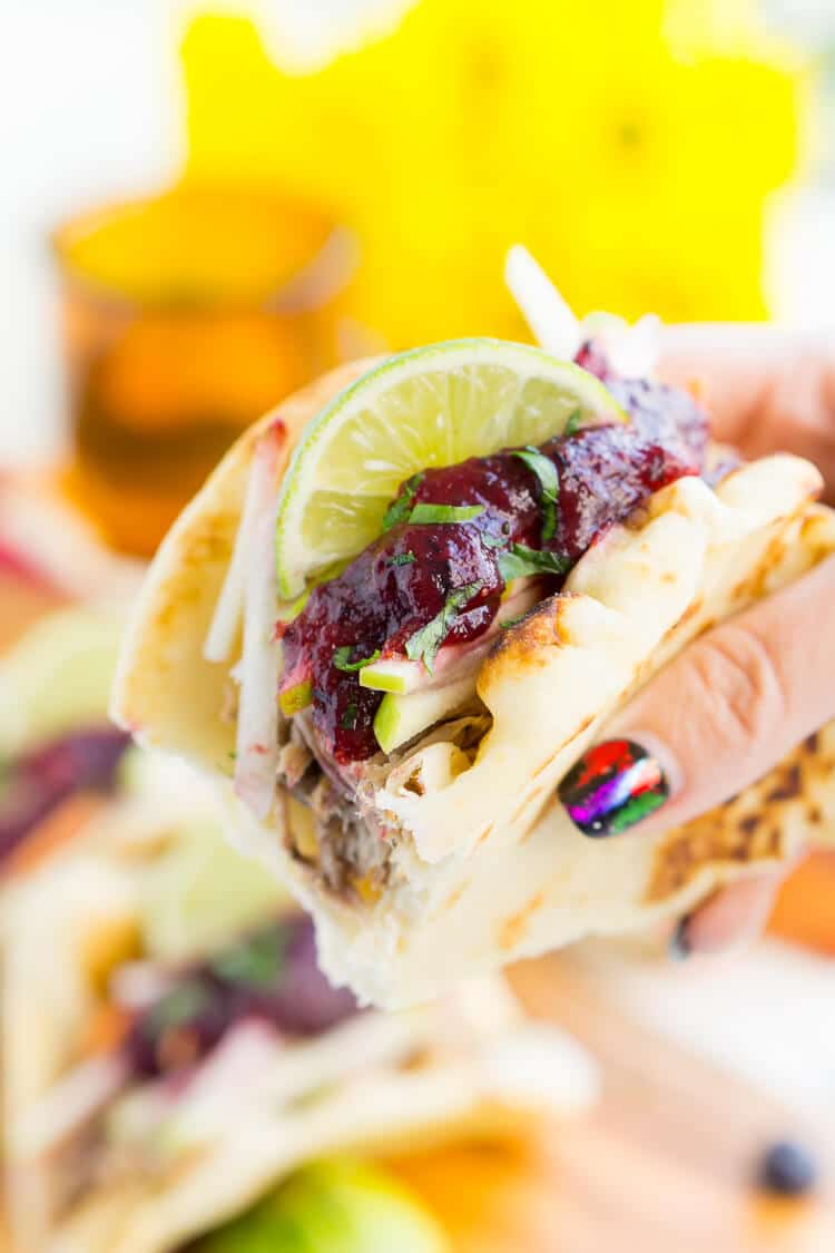 Pulled Pork Tacos with Blueberry Barbecue Sauce are perfect for game days and weeknights! A pork shoulder is slow cooked in root beer, topped with an apple slaw and homemade blueberry barbecue sauce all nestled in delicious naan bread!