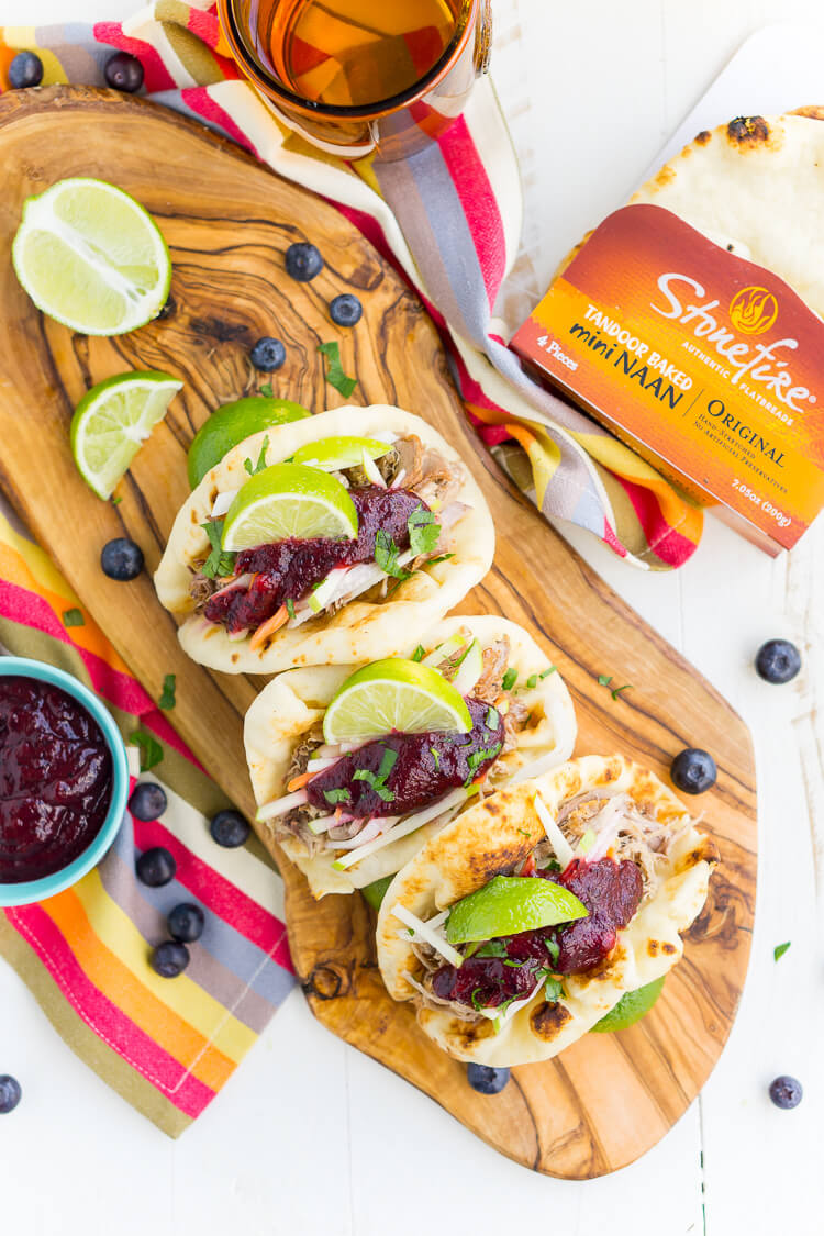 Pulled Pork Tacos with Blueberry Barbecue Sauce are perfect for game days and weeknights! A pork shoulder is slow cooked in root beer, topped with an apple slaw and homemade blueberry barbecue sauce all nestled in delicious naan bread!