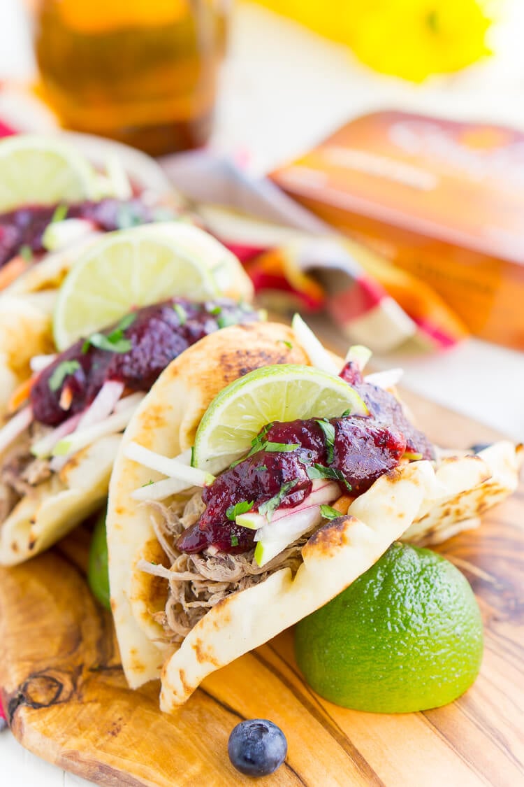 Pulled Pork Tacos with Blueberry Barbecue Sauce are perfect for game days and weeknights! A pork shoulder is slow cooked in root beer, topped with an apple slaw and homemade blueberry barbecue sauce all nestled in delicious naan bread!