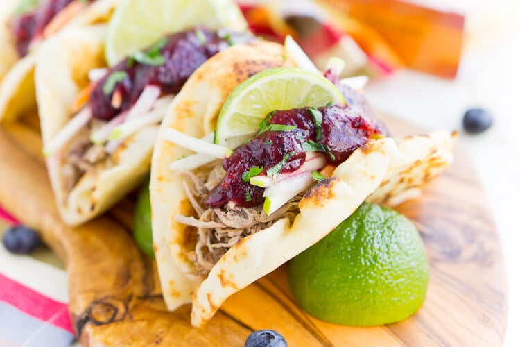 Pulled Pork Tacos with Blueberry Barbecue Sauce are perfect for game days and weeknights! A pork shoulder is slow cooked in root beer, topped with an apple slaw and homemade blueberry barbecue sauce all nestled in delicious naan bread!