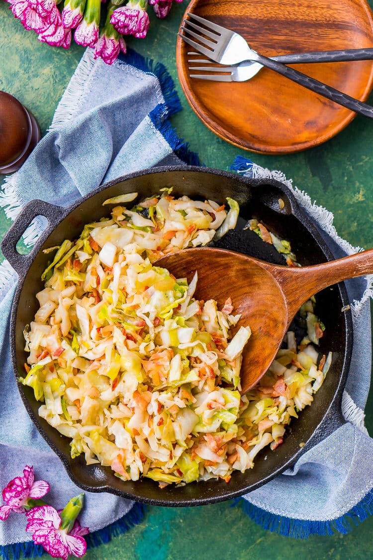 Overhead photo of fried cabbage and bacon in a cast iron skillet.