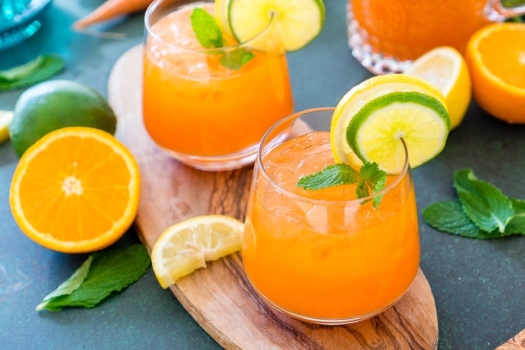 This Carrot Orange Punch is the perfect drink for spring, an easy mix of juice, soda, and fruit slices. It only takes 5 minutes to make and you can add alcohol if you want for a boozy punch!