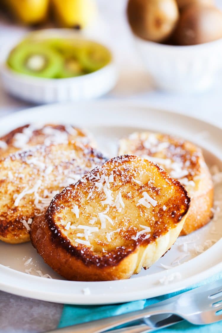 This Coconut French Toast is an easy breakfast that's served with an addictively delicious and creamy coconut syrup made with butter, buttermilk, sugar, and coconut extract!
