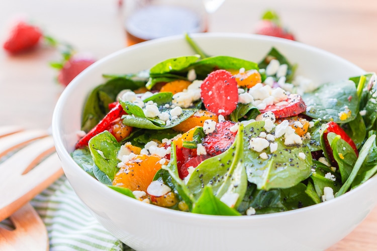 This Strawberry Spinach Salad will become your new go-to recipe for summer, it's made with simple, flavorful ingredients like goat cheese, almonds, poppyseeds, strawberries, mandarins, and spinach, and you can make it family or party-sized!