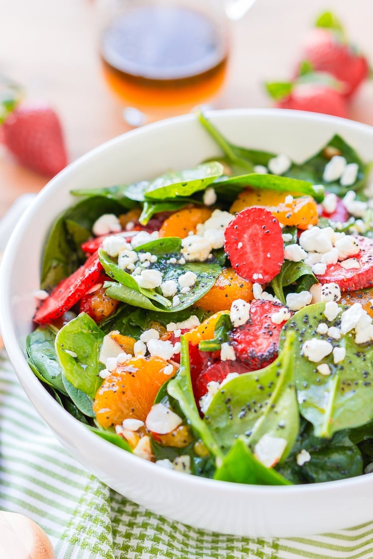 This Strawberry Spinach Salad will become your new go-to recipe for summer, it's made with simple, flavorful ingredients like goat cheese, almonds, poppyseeds, strawberries, mandarins, and spinach, and you can make it family or party-sized!