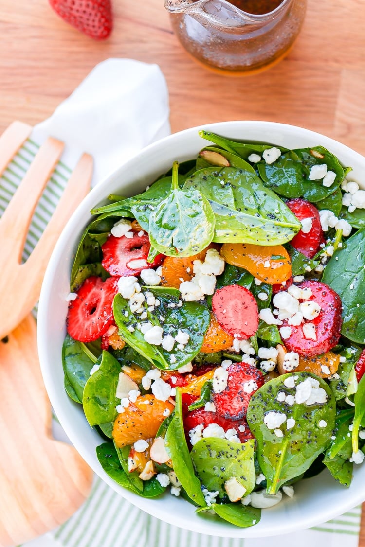 This Strawberry Spinach Salad will become your new go-to recipe for summer, it's made with simple, flavorful ingredients like goat cheese, almonds, poppyseeds, strawberries, mandarins, and spinach, and you can make it family or party-sized!