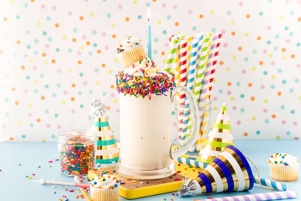 Close up of a birthday cake milkshake in a tall glass mug.