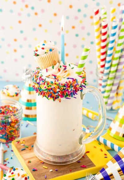 Close up of a birthday cake milkshake in a tall glass mug.