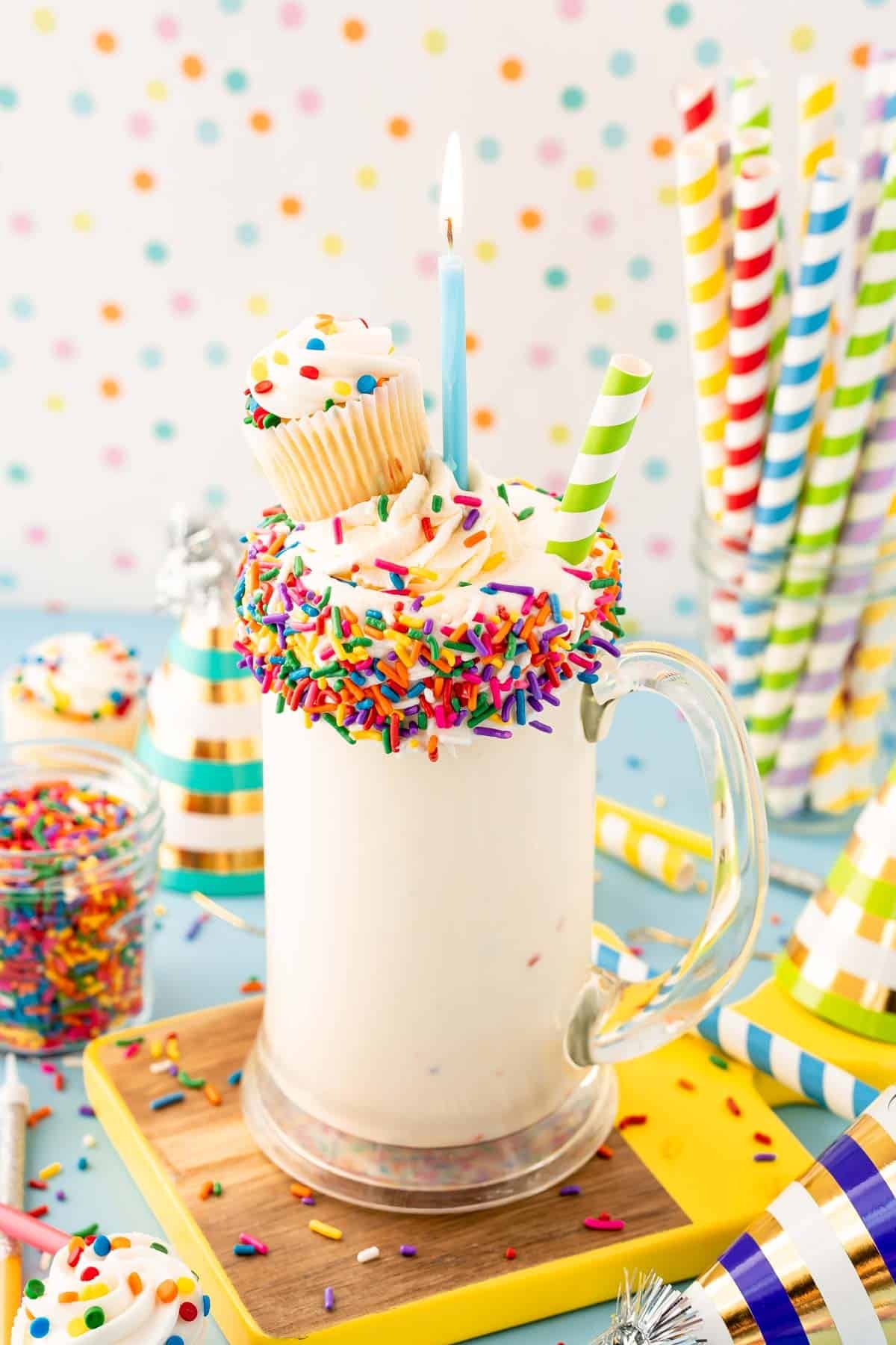 Close up of a birthday cake milkshake in a tall glass mug.