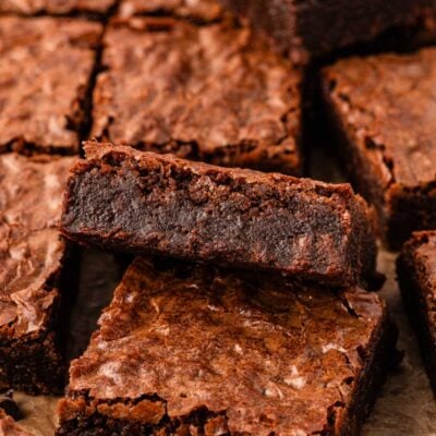 Close up photo of fudge brownies sliced on a piece of parchment.