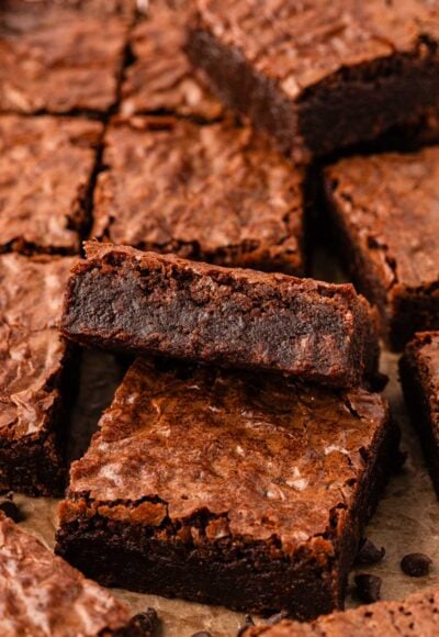 Close up photo of fudge brownies sliced on a piece of parchment.