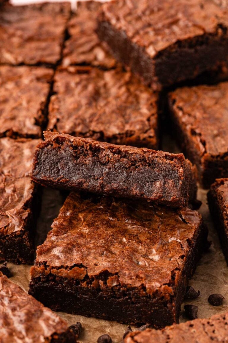 Close up photo of fudge brownies sliced on a piece of parchment.