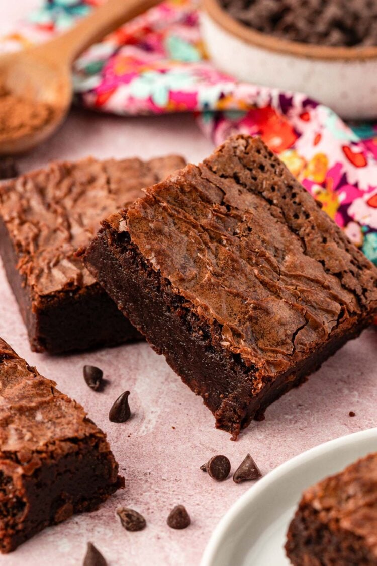 Close up photo of brownie squares on a pink surface.