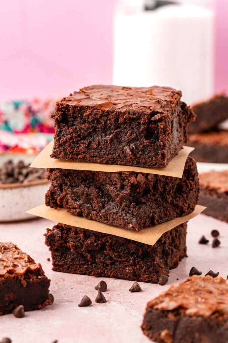 A stack of three thick brownies on a table.