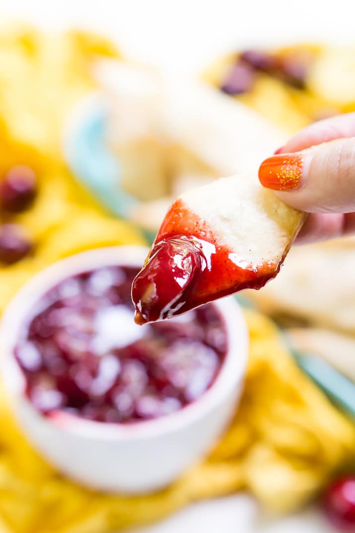 This Cherry Pie Dip is all the deliciousness of the classic pie but easier to make and perfect for parties! Fresh cherries are simmered into a thick and gooey dip served with cinnamon sugar pie chips!