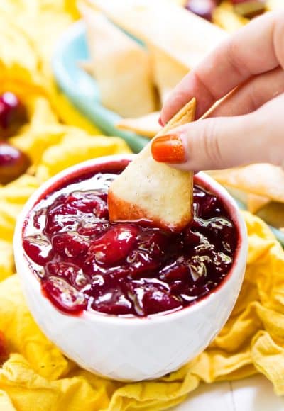 This Cherry Pie Dip is all the deliciousness of the classic pie but easier to make and perfect for parties! Fresh cherries are simmered into a thick and gooey dip served with cinnamon sugar pie chips!