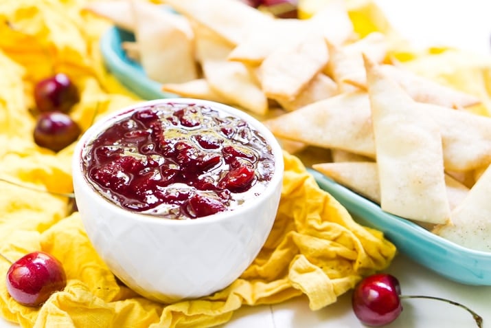 This Cherry Pie Dip is all the deliciousness of the classic pie but easier to make and perfect for parties! Fresh cherries are simmered into a thick and gooey dip served with cinnamon sugar pie chips!