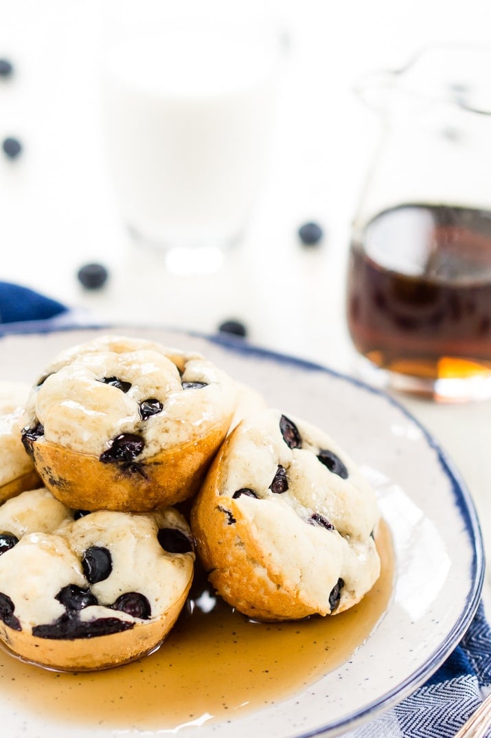 Blueberry Pancake Muffins to proste, przenośne, 4-składnikowe śniadanie lub przekąska, które pokochasz Ty i twoje dzieci. Idealny dla tych szalonych szkolnych poranków lub weekendów w podróży lub możesz cieszyć się nimi w domu z masłem i syropem klonowym!