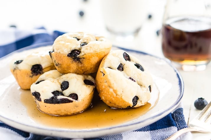  Blueberry Pancake Muffins er en enkel, bærbar, 4-ingrediens morgenmad eller snack både du og dine børn vil elske. Perfekt til de skøre skolemorgener eller ugedage på farten, eller du kan nyde dem derhjemme med smør og ahornsirup!