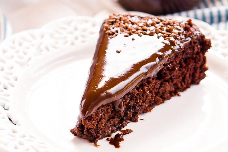 Slice of chocolate wacky cake on a white plate.