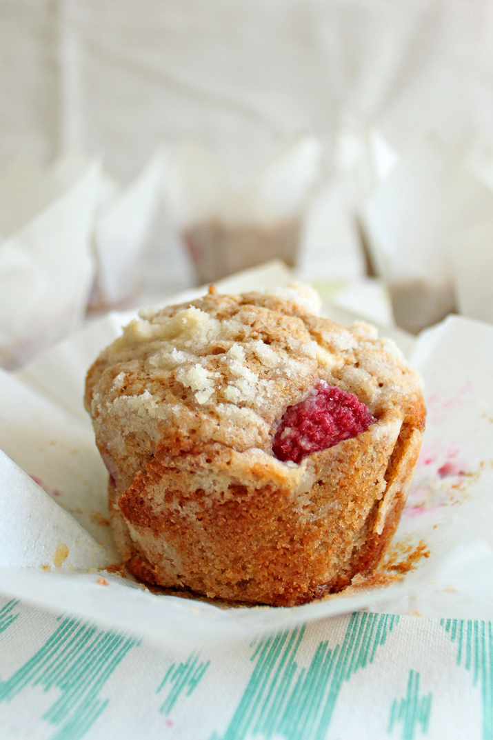 These Raspberry White Chocolate Chip Muffins are made with whole wheat flour. They are so soft and fluffy, and bursting with fresh raspberries! | wildwildwhisk.com