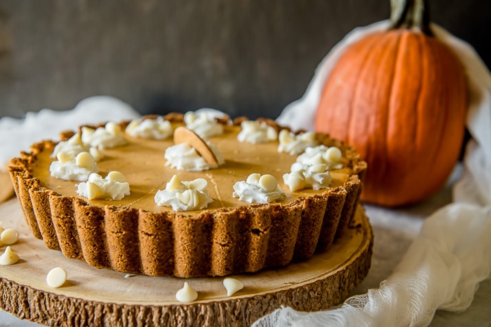 Present that traditional pumpkin pie in a more festive way with this White Chocolate Pumpkin Cheesecake Tart! Pumpkin cheesecake, infused with white chocolate and nestled in a gingersnap crust, is going to be your new favorite holiday dessert!