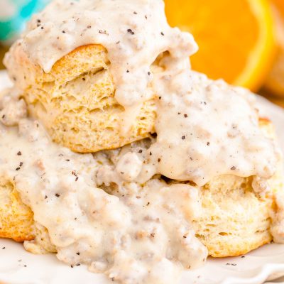 Close up photo of biscuits and sausage gravy on a white plate.