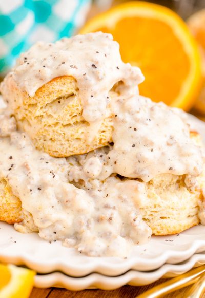 Close up photo of biscuits and sausage gravy on a white plate.