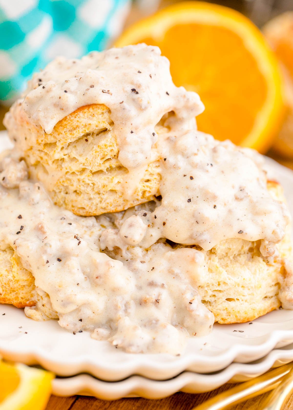 Close up photo of biscuits and sausage gravy on a white plate.