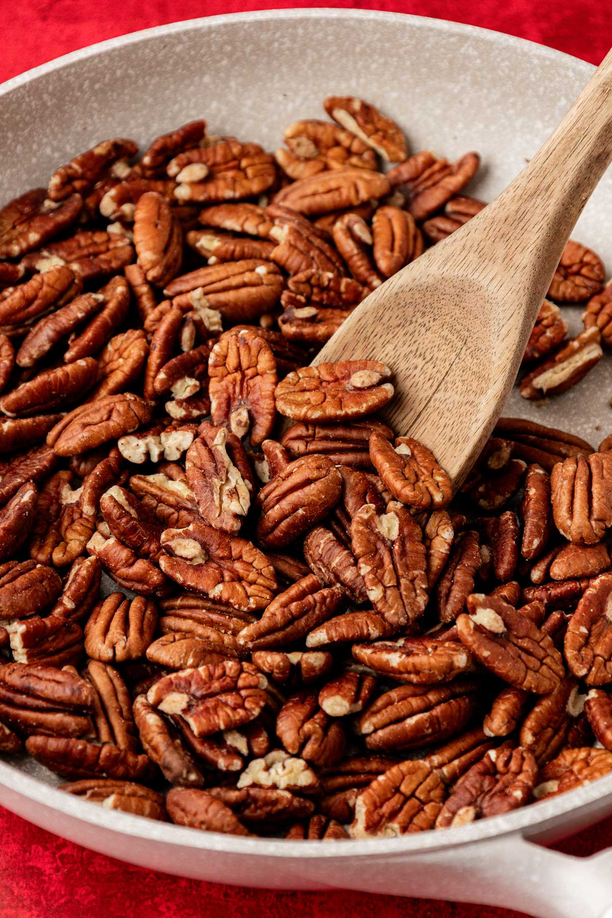 Pecan halves being toasted in a skillet.