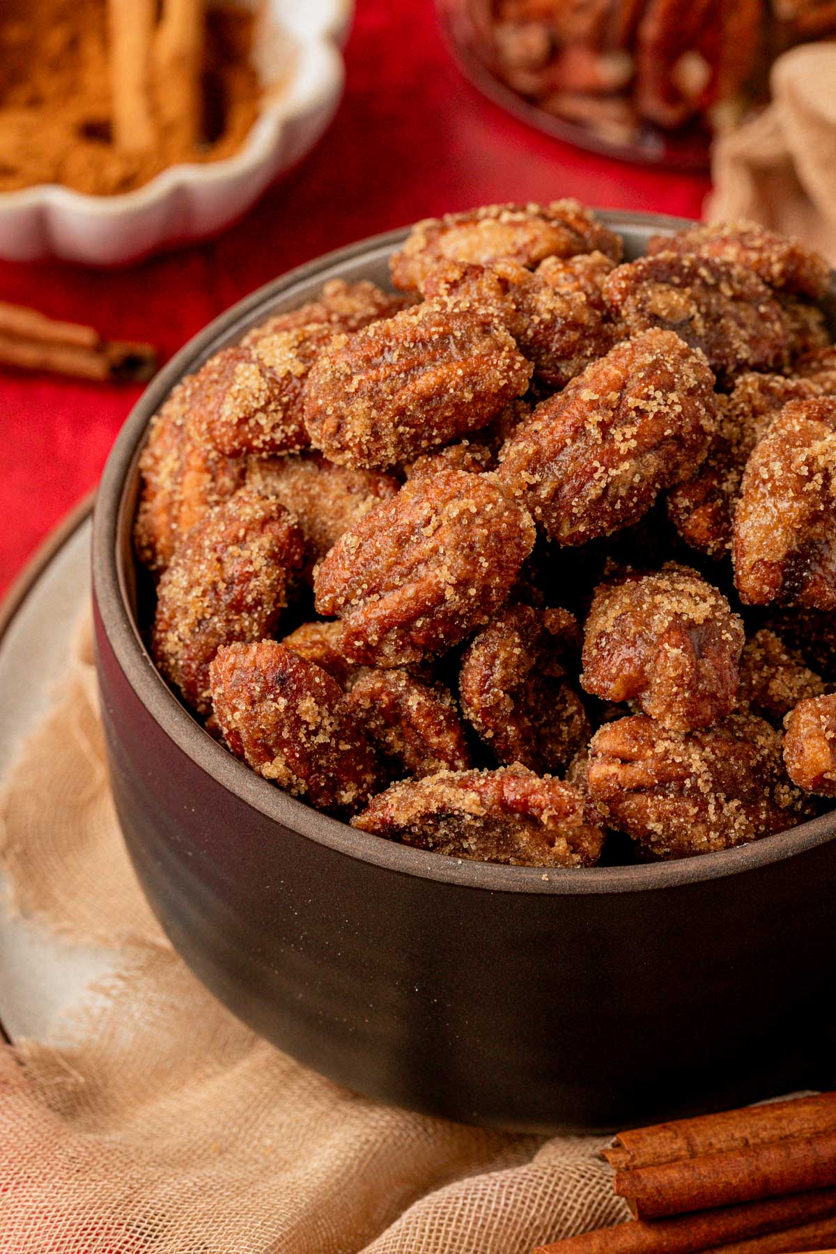 A black bowl filled with candied pecans.