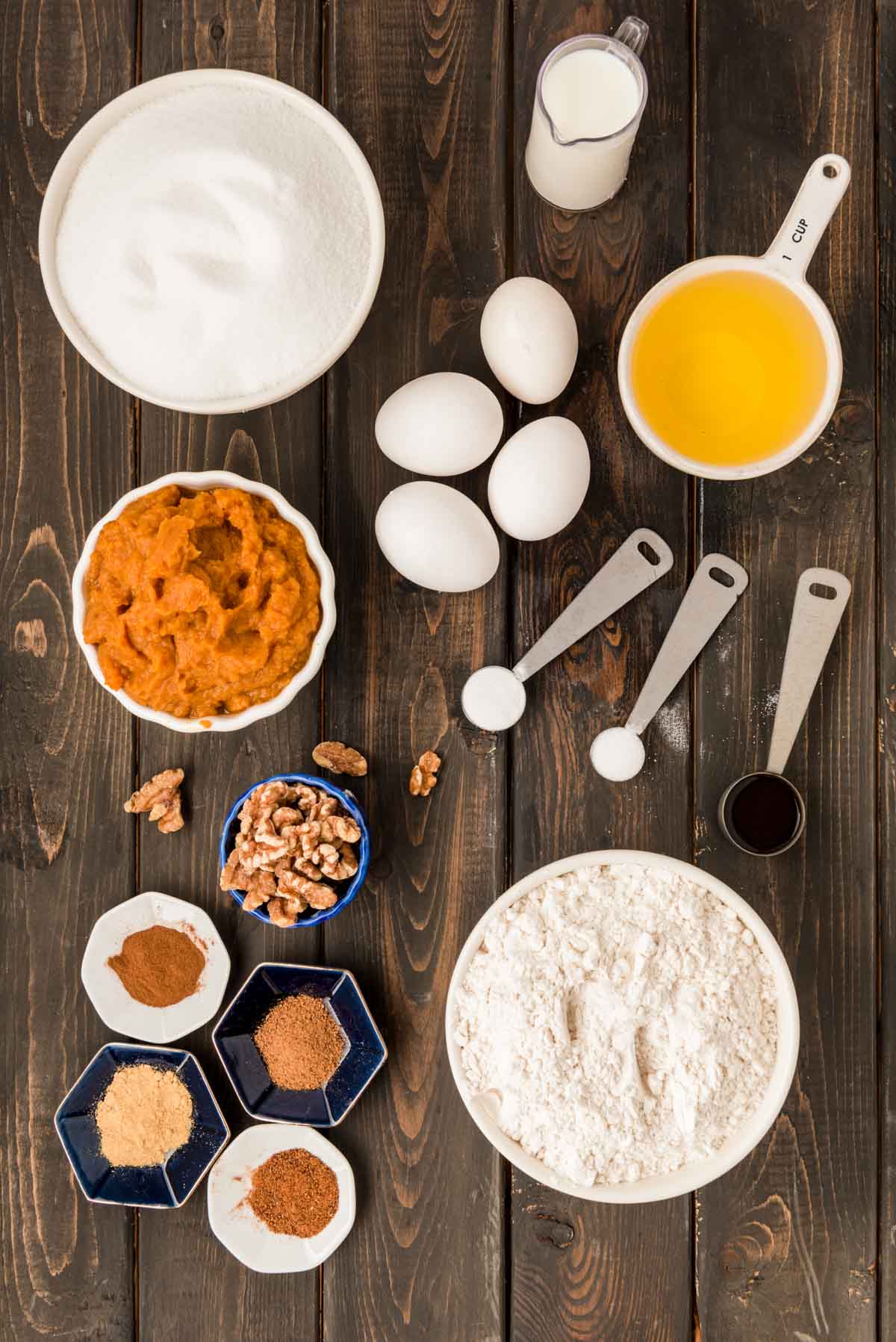 Overhead photo of ingredients to make pumpkin bread on a wooden table.
