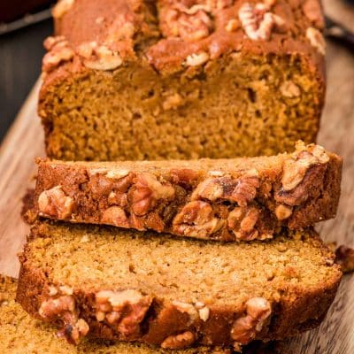 Close up of a partially sliced loaf of pumpkin bread.