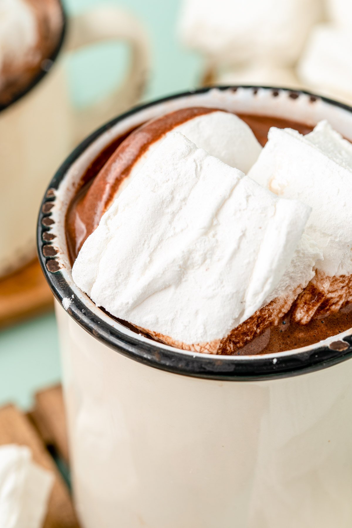 Homemade marshmallows in a white mug filled with hot chocolate.