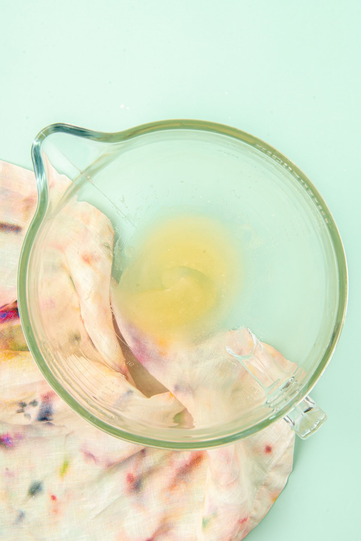 Gelatin and water in a glass mixing bowl.